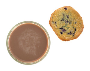 Chocolate milk with a blueberry muffin top view on a white background.