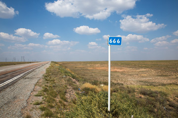 three sixes kilometer mark on summer road and cloudy sky background