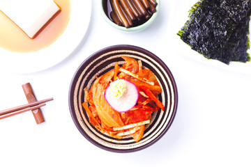 Top view of a bowl of Kimchi on a white table.