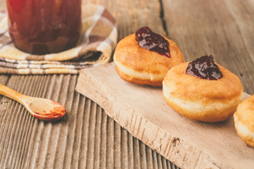 Homemade donuts with jam on wooden table