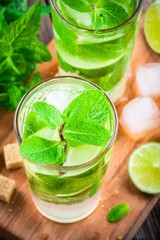 fresh cocktails with lime, mint and ice in glass
