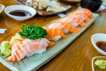 Salmon sushi with wasabi on plate inside Japanese restaurant