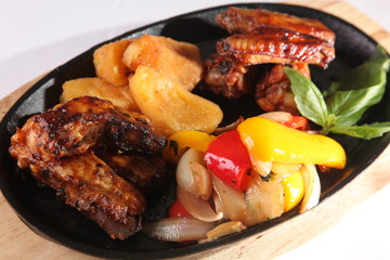 metal pan with chicken wings and vegetables