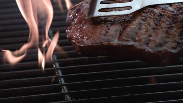 T-Bone steak on grill in slow motion, shot on Phantom Flex 4K