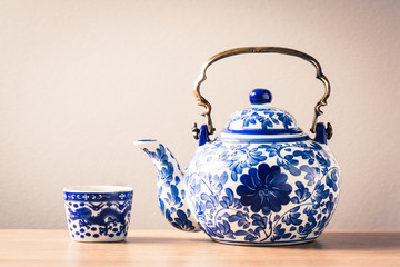 still life photography : traditional chinaware teapot and tea in cup on wood table ( blue and white pottery )