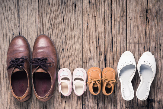 still life photography : father mother son and daughter shoes on old wood floor, family concept