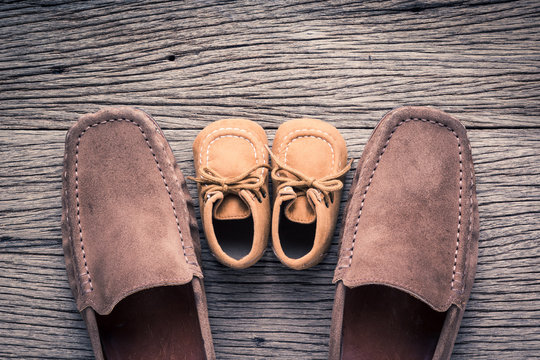 still life photography : father and child shoes on old wood in vintage color tone, go ahead together concept