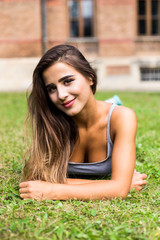 Beautiful woman relaxing at the park lying on grass