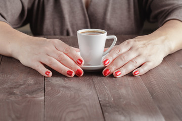 Fototapeta na wymiar Close up portrait of female hands holding cup of coffee