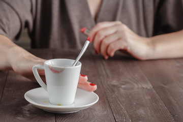Cup of tested coffee with track of red lipstick