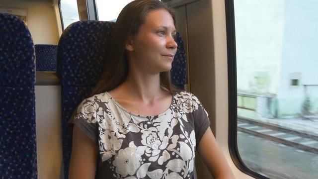 Woman comfortably sitting in train by the window