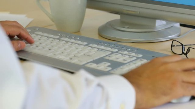 Timelapse shot of businessman typing on keyboard at office desk