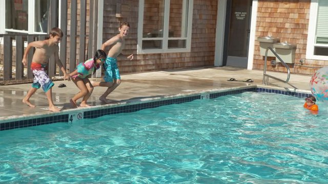 Kids jumping into pool in slow motion, shot on Phantom Flex 4K