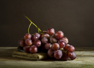 Bunch of ripe grapes on a plate, and sacking.
