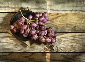 Bunch of ripe grapes on a plate, and sacking.
