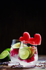 Watermelon lime lemonade with ice in glasses, decorated with fru