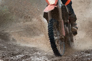 Papier Peint photo Sport automobile Motocross driver splashing mud on wet and muddy terrain