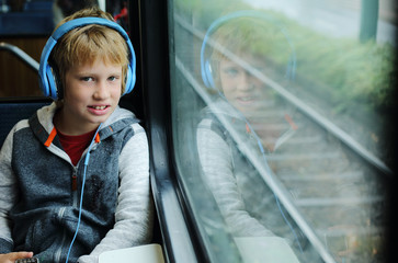 Cute 8 years old boy looking through the window in the train