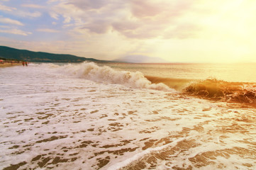 Wave on sea with beach and burning sky background
