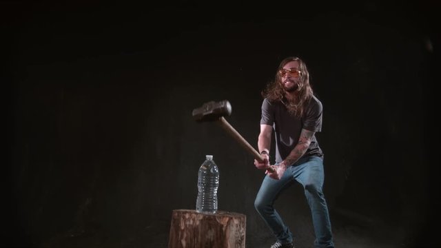 Man smashing bottle of water with hammer in slow motion, shot on Phantom Flex 4K at 1000 fps