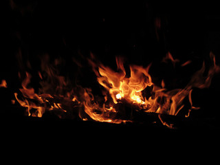 Fototapeta na wymiar Burning fireplace with fire flames on black background