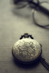 Old pocket watch and  glasses in close up