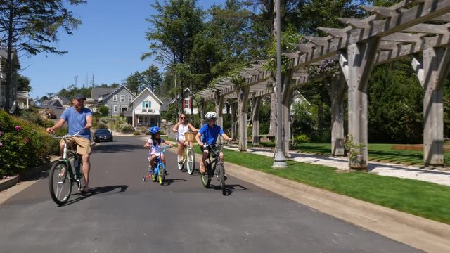 Family riding bicycles together in coastal vacation community