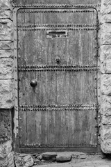 wooden door of an stone building black and white