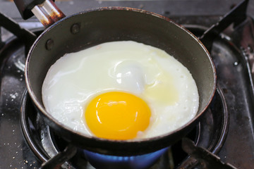 Egg. Fried egg. Chicken egg. Close up view of the fried egg on a frying pan. Salted and spiced fried egg.