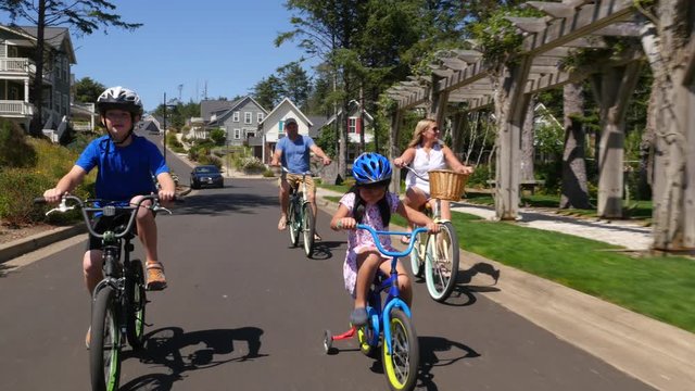 Family riding bicycles together in coastal vacation community