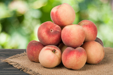heap of peaches on a wooden table with blurred background