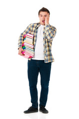 Full lenght portrait of shocked teenager with books. Male student expressing shocking emotions. Young man holding textbooks isolated on the white background.