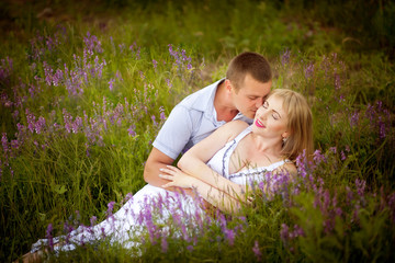 Young man and woman couple in love lying in the grass on the nature or flowers