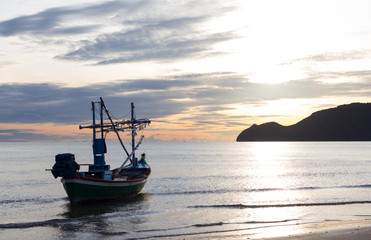 Naklejka premium fishing boat in a morning on the beach sunrise