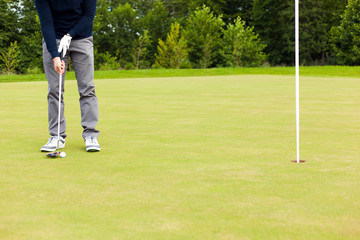 Male golf player drivers the ball into the hole