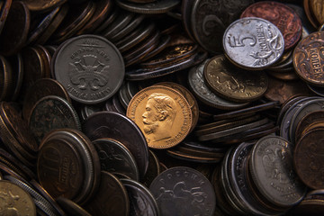 old russian coin from precious metal in a heap of modern coins of small face value