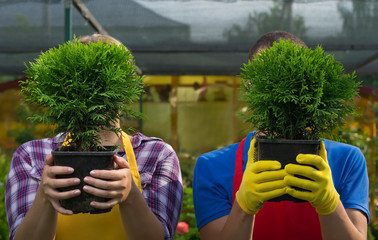 Man and woman hiding behind trees