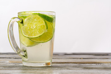 lime glass and a glass of drink on a wooden table