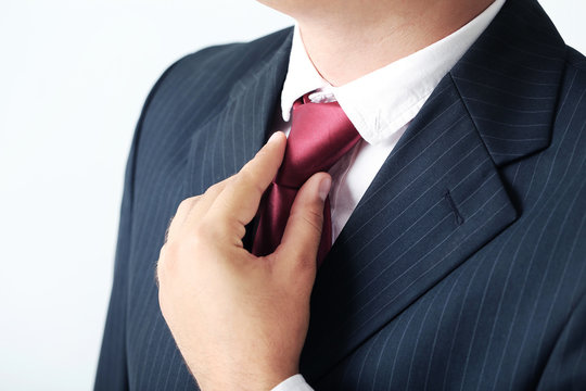 Businessman In Black Suit Tying The Necktie