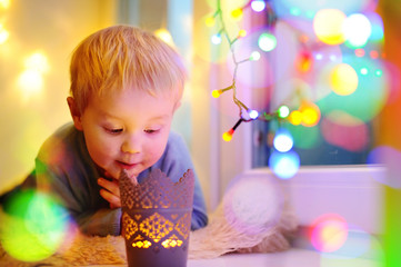 Fototapeta na wymiar Cute little boy looking on a magical Christmas or New Year gift