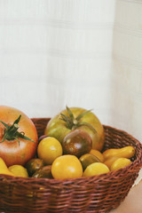 Cesta con tomates de tamaños y colores variados 