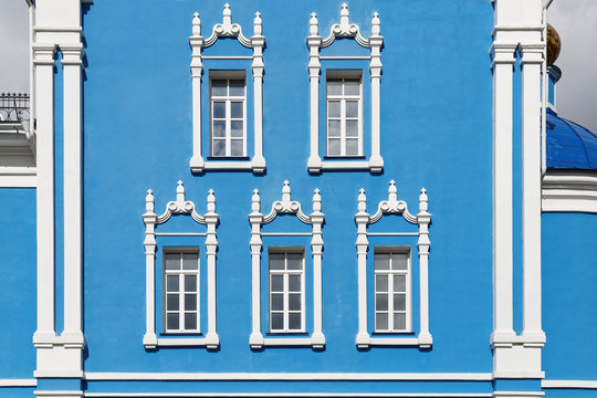 White window on a blue wall on a building facade