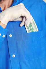Hand in glove gets bill from his pocket close up