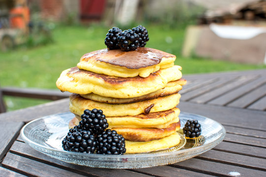 Germany, Kalbe: homemade stack of pancakes with fresh blackberrys on a glass plate