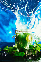 Bank mojito with lime and mint ice cube falling splash