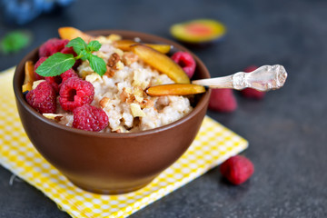 Oatmeal with berries, plums, nuts and honey for breakfast