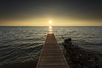 Fototapeta na wymiar Empty pontoon over a lake at sunrise