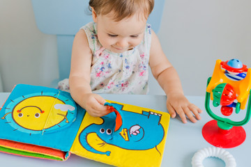 small child playing with soft book