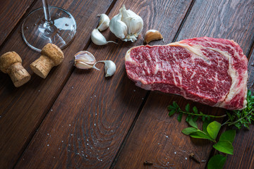 Raw beef rib eye steak on wooden background
