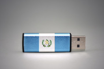 usb flash drive with the national flag of guatemala on gray background.